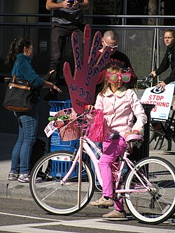activist medea benjamin protesting on a bicycle